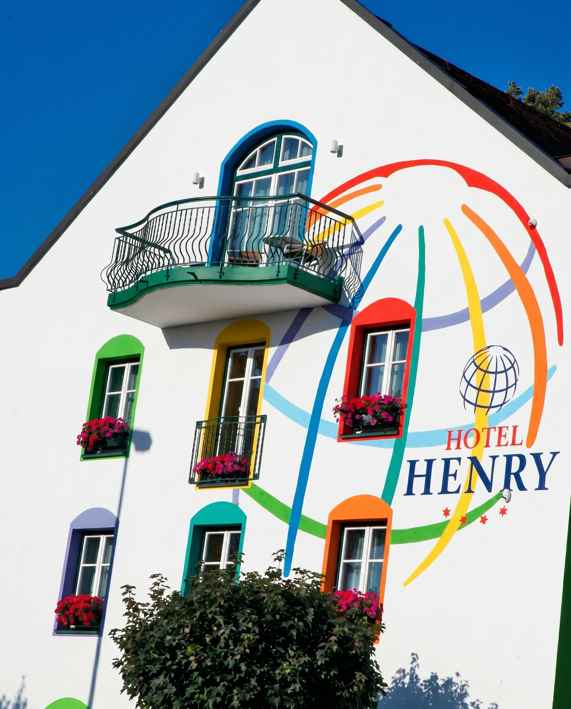 Die echte Fassade des Hotel Henry mit dem bunten Weltkugel-Wandbild (Originalaufnahme, digital aufbereitet).